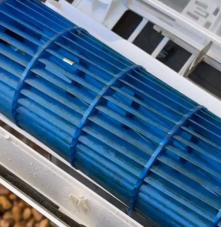 Turbina azul e componentes internos de ar-condicionado em registro de higienização